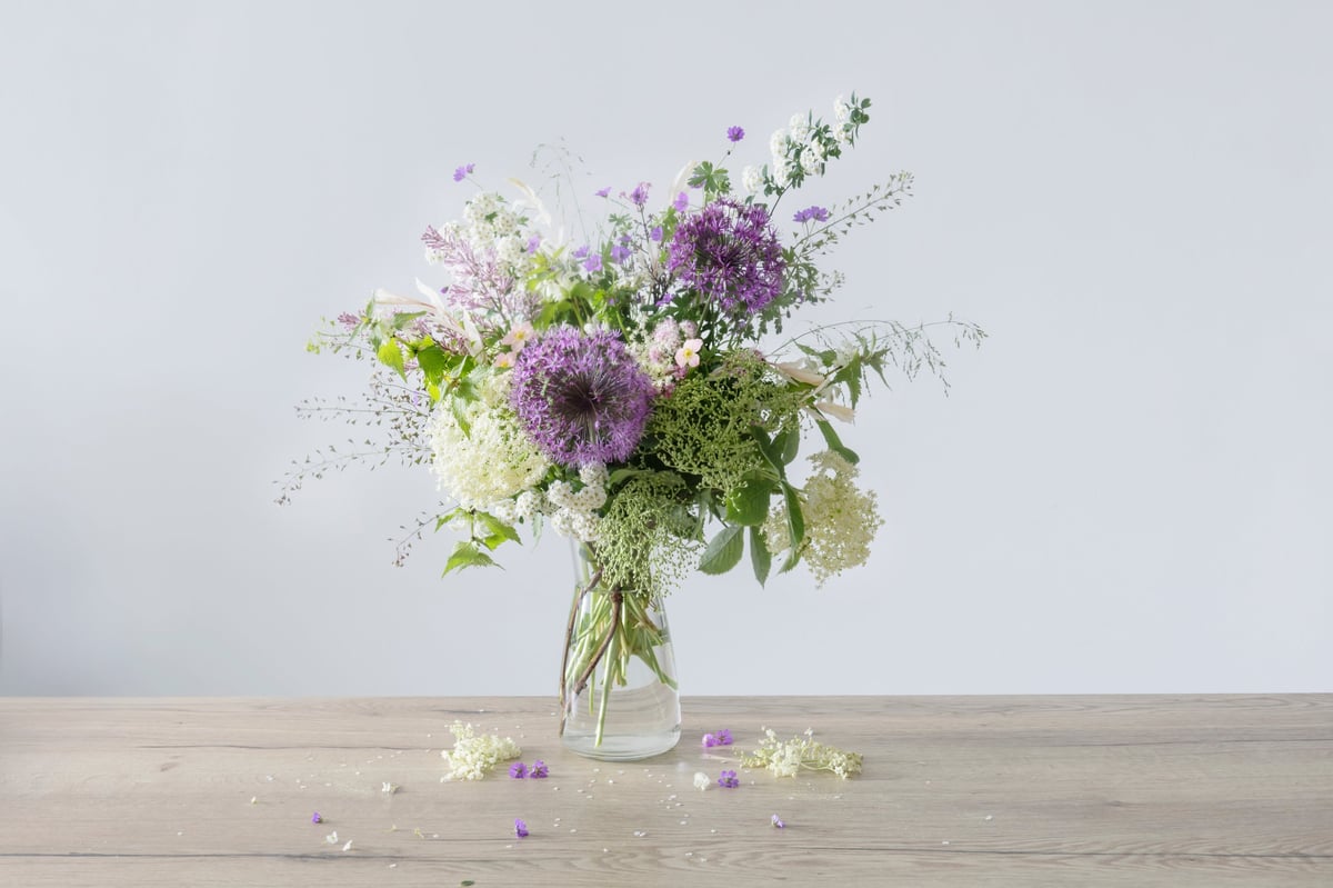 Wildflowers in glass vase on wooden table